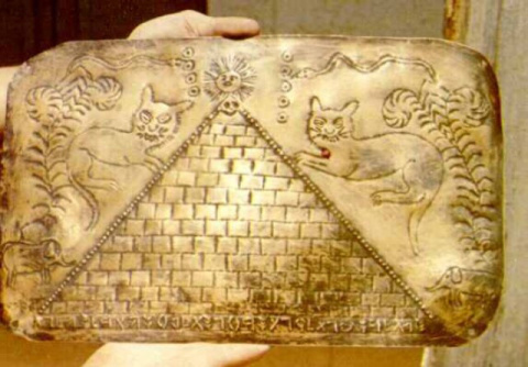 A metal plate containing a pyramid with the sun.